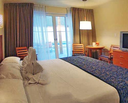 A well furnished bedroom with television and dining area.