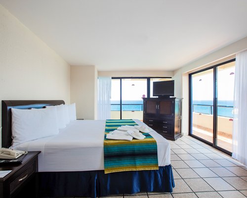A well furnished bedroom with ocean view.
