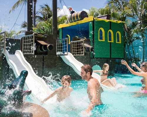 View of people playing at outdoor water theme park.