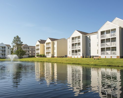 An exterior view of multi story resort condos alongside a waterfront.