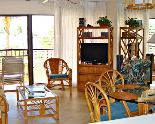 A well furnished living room with television dining area and balcony.