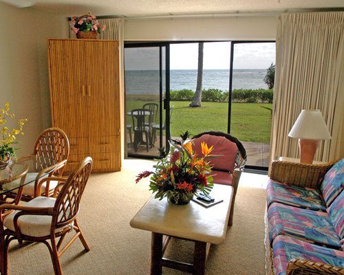 A well furnished living room with a dining area patio and beach view.
