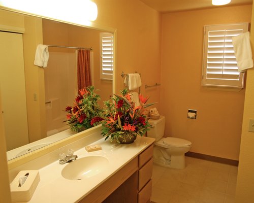 A bathroom with bathtub and open sink vanity.