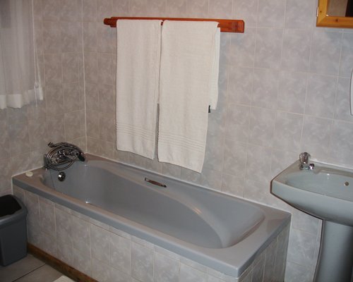 A bathroom with a single sink vanity and a bathtub.