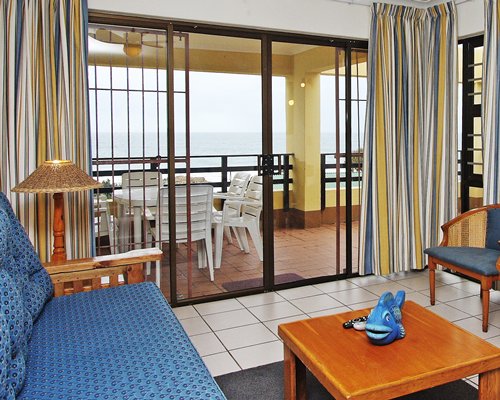 A well furnished living room alongside a balcony with patio furniture.