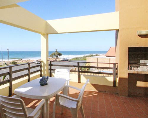View of the ocean from balcony with patio chairs.