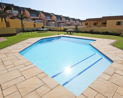 An outdoor swimming pool alongside multi story resort units.