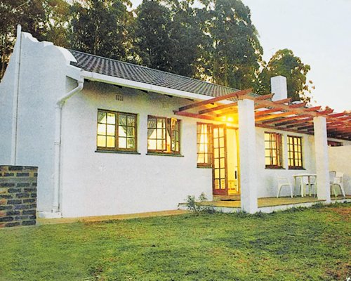 Exterior view of a unit with patio chairs at Suntide Qunu Lodge.