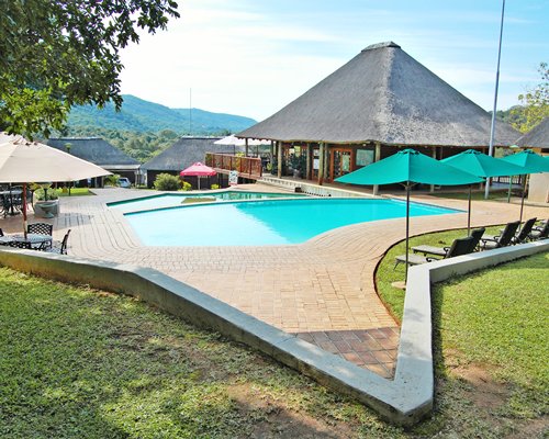 Scenic view of an outdoor swimming pool with chaise lounge chairs and patio furniture.