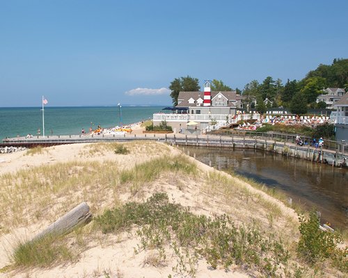 A wooden pier leading to the beach alongside resort properties.