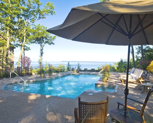 An outdoor swimming pool with chaise lounge chairs alongside the bay.