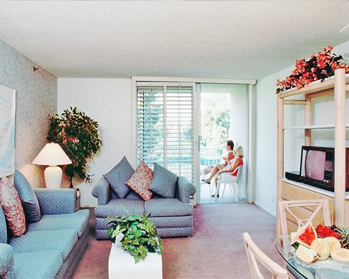 A well furnished living room with double pull out sofa and a balcony and television.