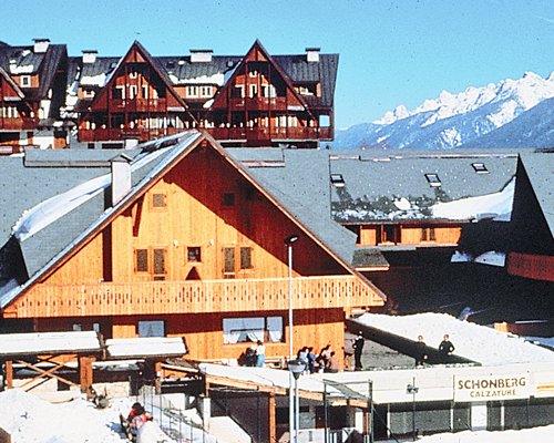 An exterior view of the Residence Camporosso II resort covered in snow.