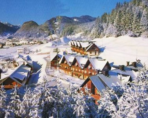 An exterior view of the Residence Camporosso II resort covered in snow.