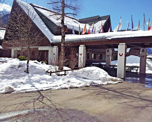 An exterior view of The Residence Camporosso II resort units covered in snow.