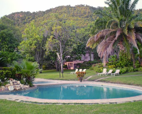 An outdoor swimming pool with chaise lounge chairs.