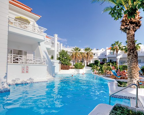 An outdoor swimming pool with chaise lounge chairs.