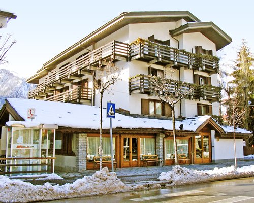 A street view of the Domina Home Les Jumeaux resort units covered in snow.