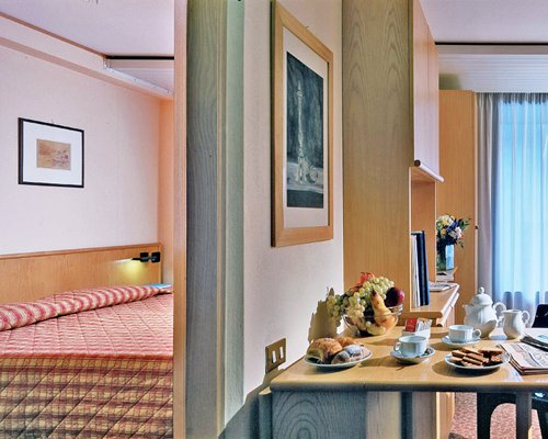 A dining room alongside a bedroom.