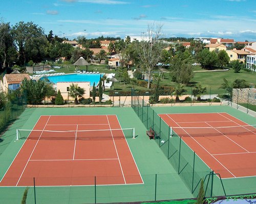 Scenic exterior view of the two tennis court alongside the swimming pool.