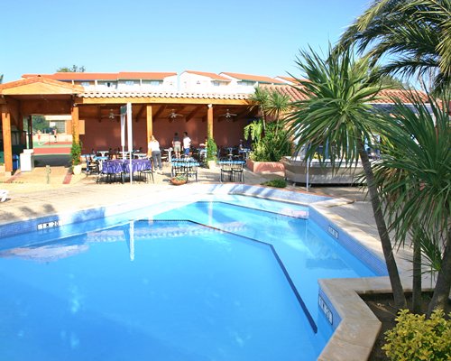 An outdoor swimming pool with patio furniture alongside the resort unit.