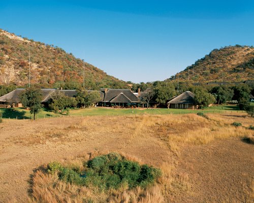 An exterior view of the Bakubung Lodge surrounded by woods.