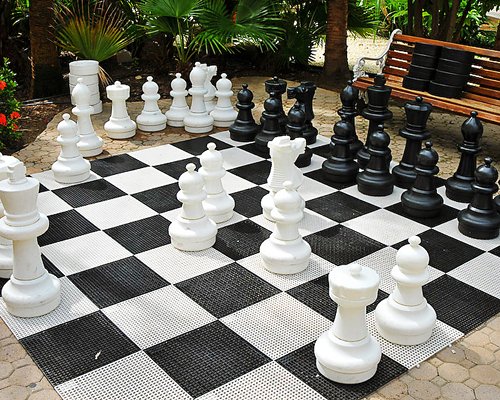 Exterior view of a giant chess set alongside picnic seat.