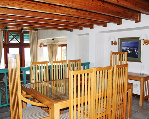 A well furnished dining room with glass top table.