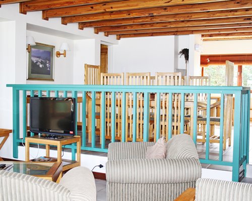 A well furnished living room with television and dining area.