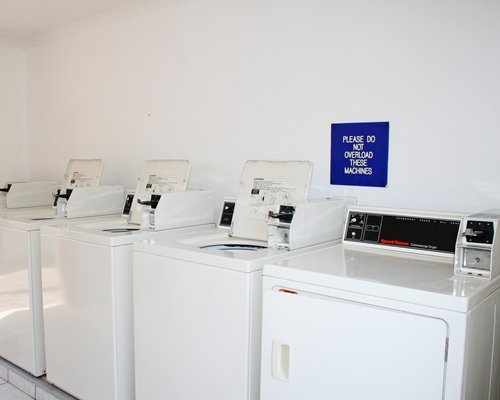 An indoor laundry room with four washing machines.
