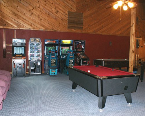 An indoor recreation room with pool tables and arcade games.