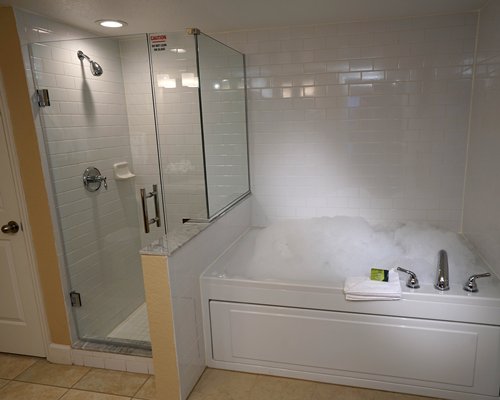 A bathroom with bathtub shower and standing shower.