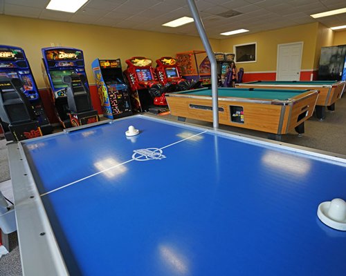 An indoor recreation room with pool table and arcade games.