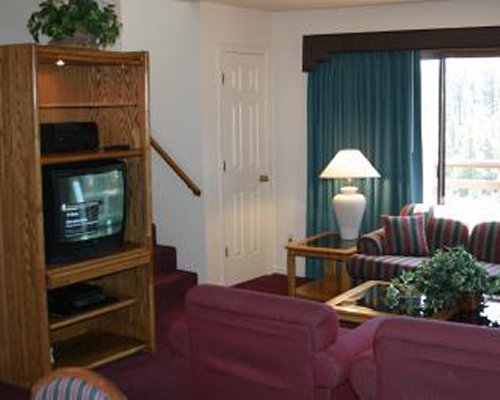 A well furnished living room with television and dining area.