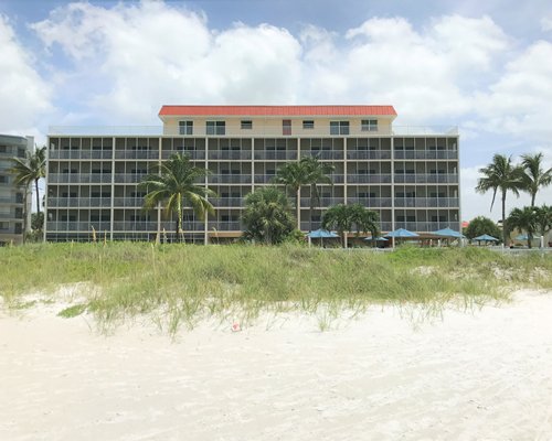 Exterior view of multiple unit balconies at Windward Passage Resort with sunshades and palm trees.
