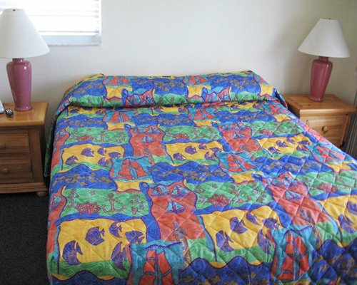 A well furnished bedroom with king bed and two lamps.