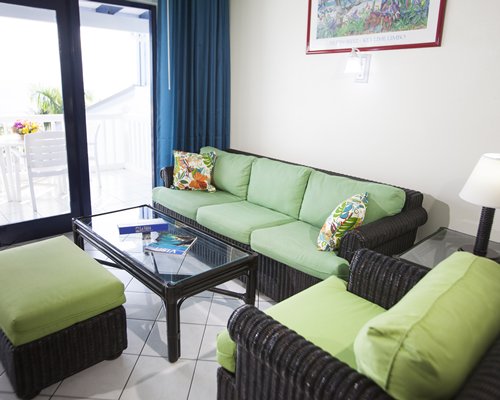A well furnished living room with a balcony and patio furniture.