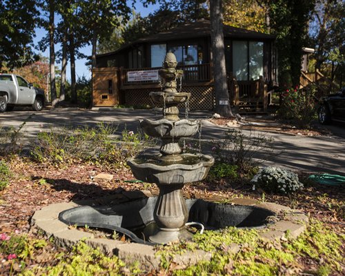 Scenic view of a fountain and pathway to a condo with parking lot at Treetop Condominiums.