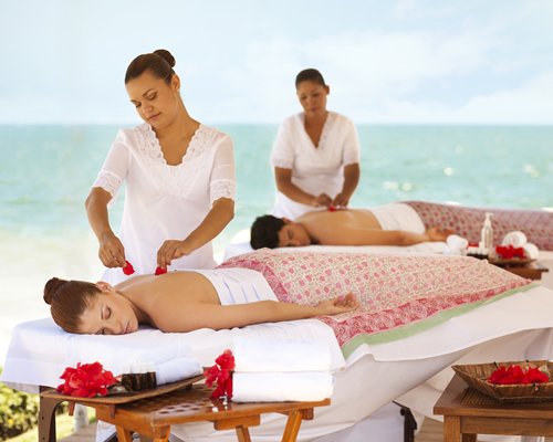 People having a body massage alongside the beach.