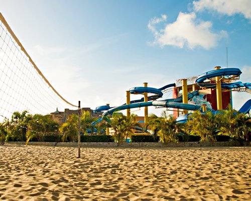 A view of beach volleyball court alongside water park.