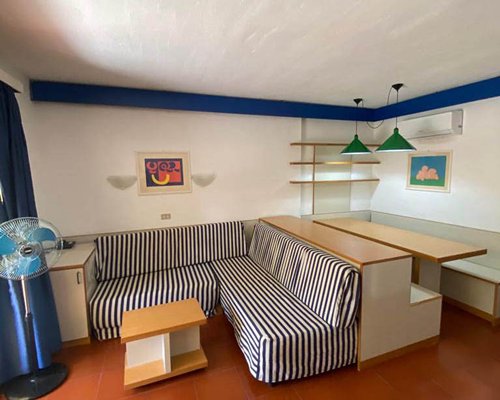 A family in an open plan living room and dining area with a television.