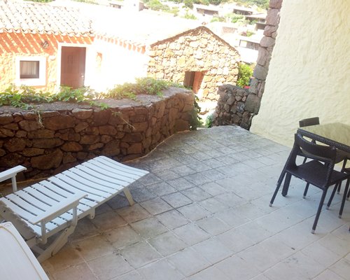 Chaise lounge chair and patio furniture in the balcony.