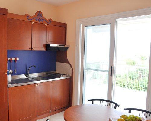 A well equipped kitchen with wooden dining area and a patio.