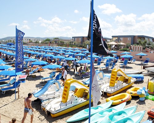 A group of people relaxing in chaise lounge chairs with sunshades.
