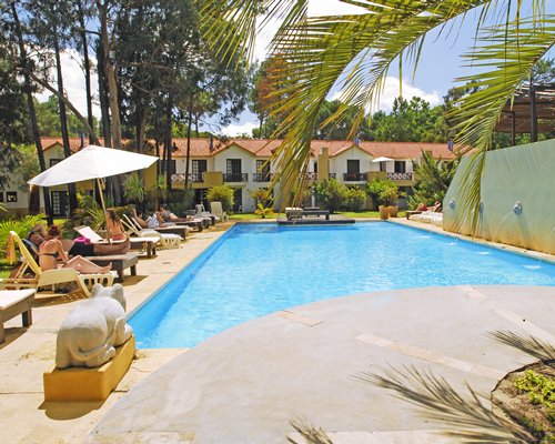 An outdoor swimming pool with chaise lounge chairs alongside the resort condos.
