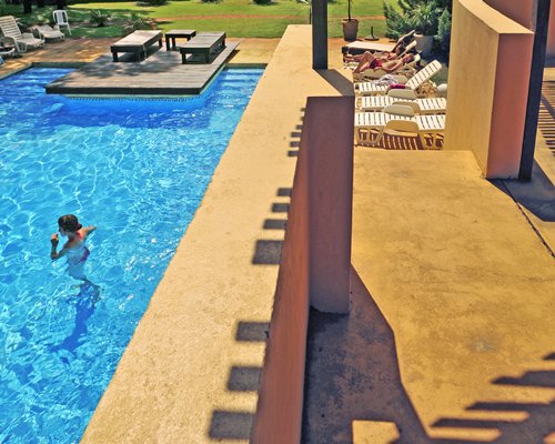 An outdoor swimming pool with chaise lounge chairs.