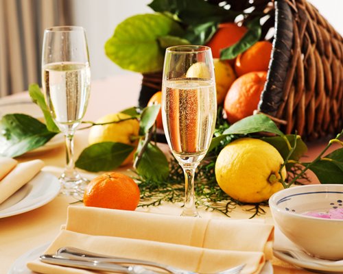 A glass of champagne and fruits on a table.