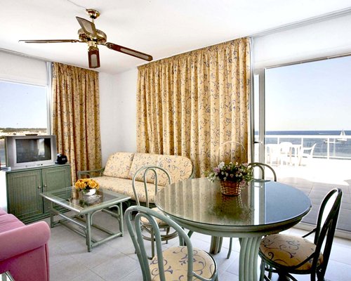 A well furnished living room with a television dining area and balcony.