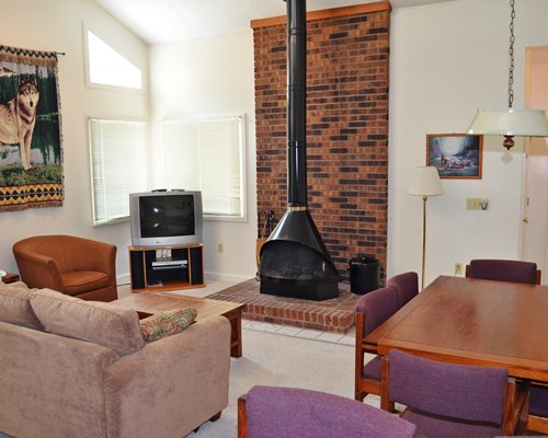 A well furnished living room with television and fireplace.