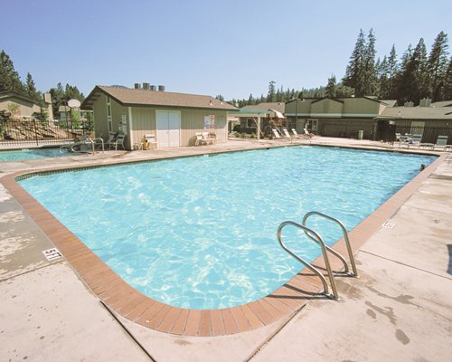 Outdoor swimming pool with chaise lounge chairs and patio chairs.